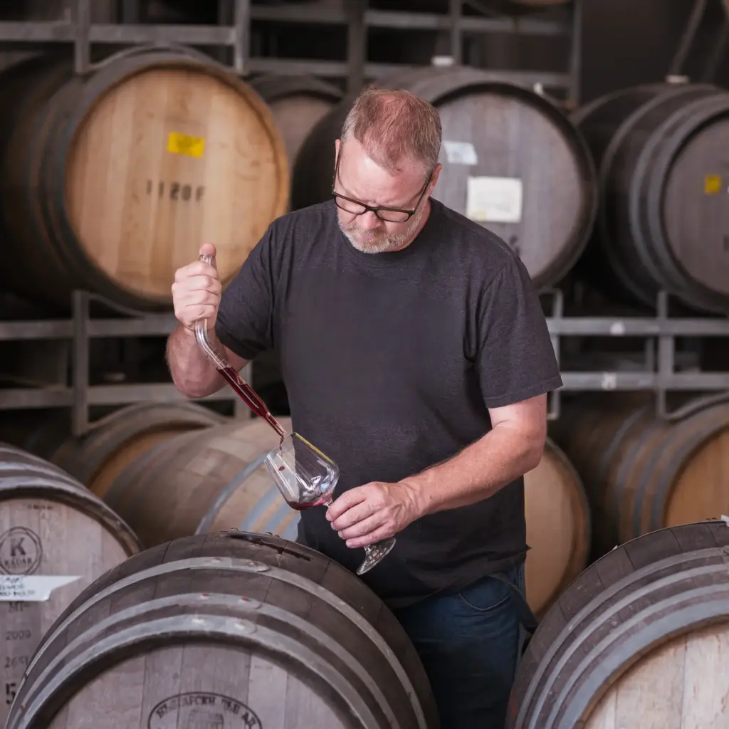 Members One Dr Wes Pearson sampling wine from a barrel at Juxtaposed Wines winery